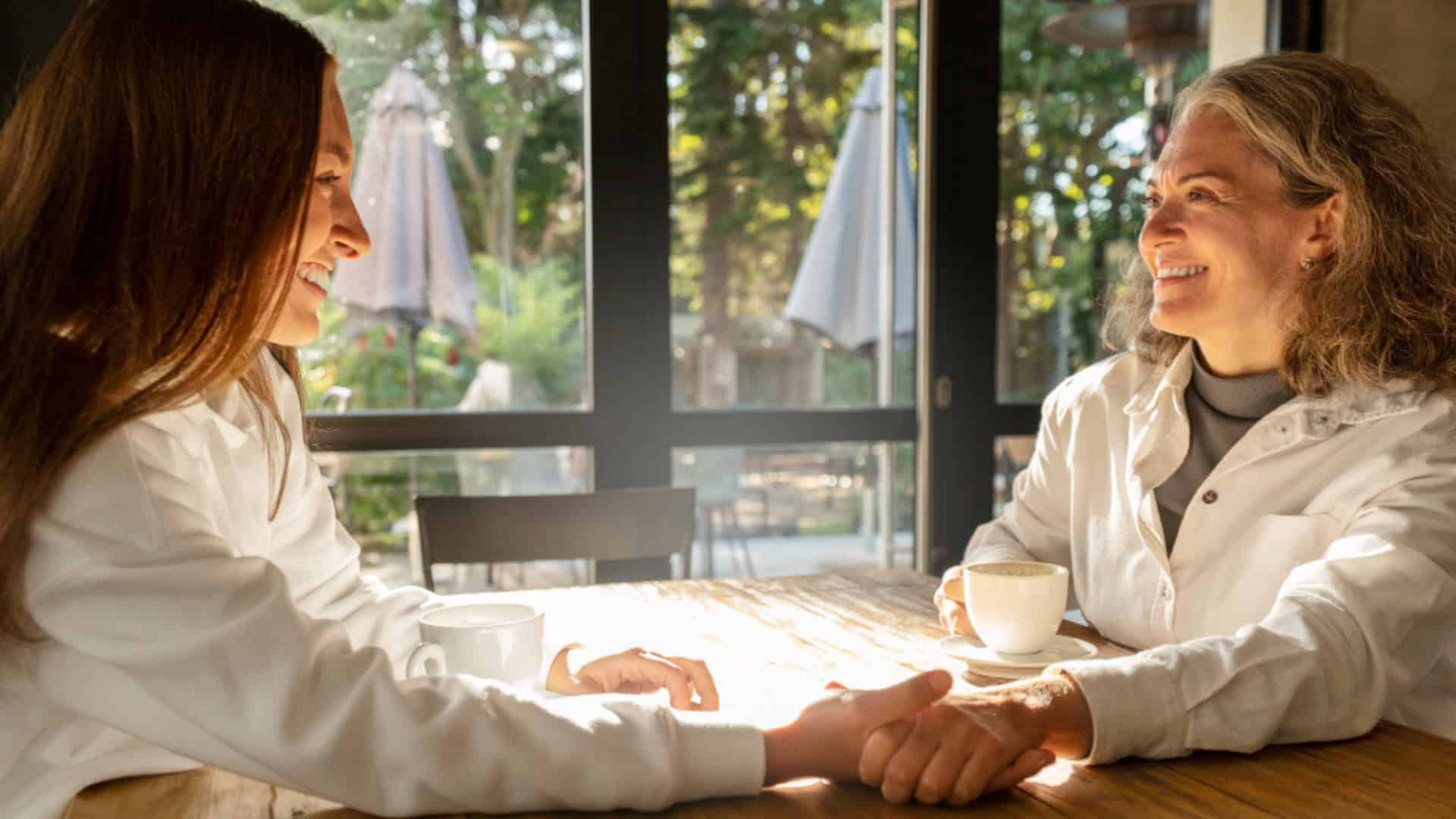 Two women sitting at a dining table, offering emotional support to each other as part of depression treatment in Orange County